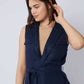Woman wearing sleeveless navy blue belted vest with deep V-neck and flap pockets