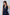 Woman wearing sleeveless navy blue belted vest with deep V-neck and flap pockets