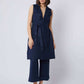 Woman wearing sleeveless navy belted tunic and wide-leg pants set, neutral heels