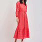 Woman wearing a coral eyelet long dress with long sleeves from Dalydress, styled with white sneakers.