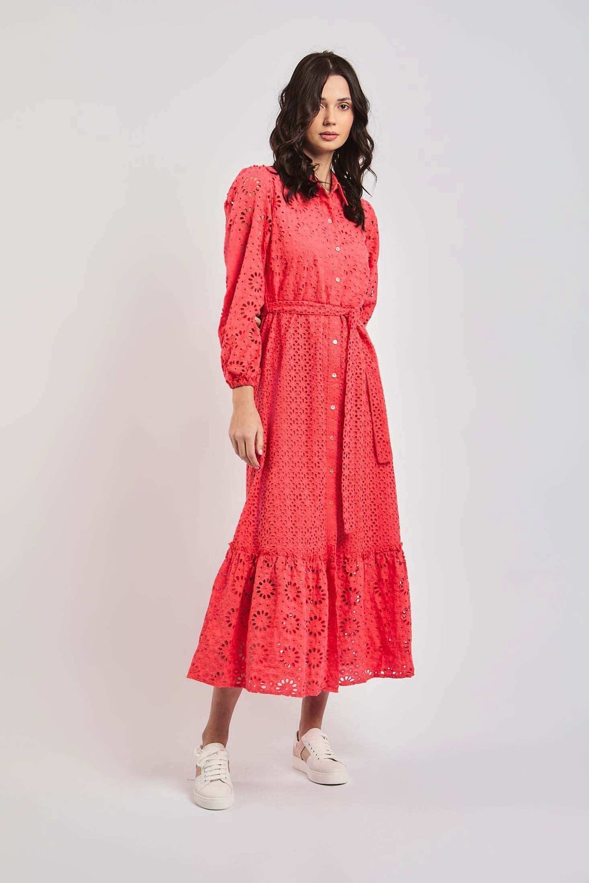 Woman wearing a coral eyelet long dress with long sleeves from Dalydress, styled with white sneakers.