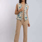 Woman wearing sleeveless embroidered vest with floral pattern over beige casual outfit