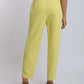 Woman wearing high-waisted yellow pants and brown heels, back view, casual fashion