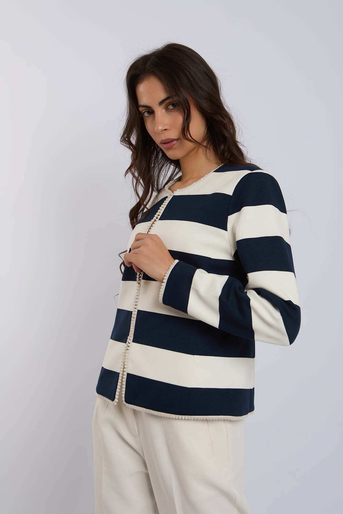 Woman wearing Dalydress navy and white striped blazer with pearl trim, urban fashion