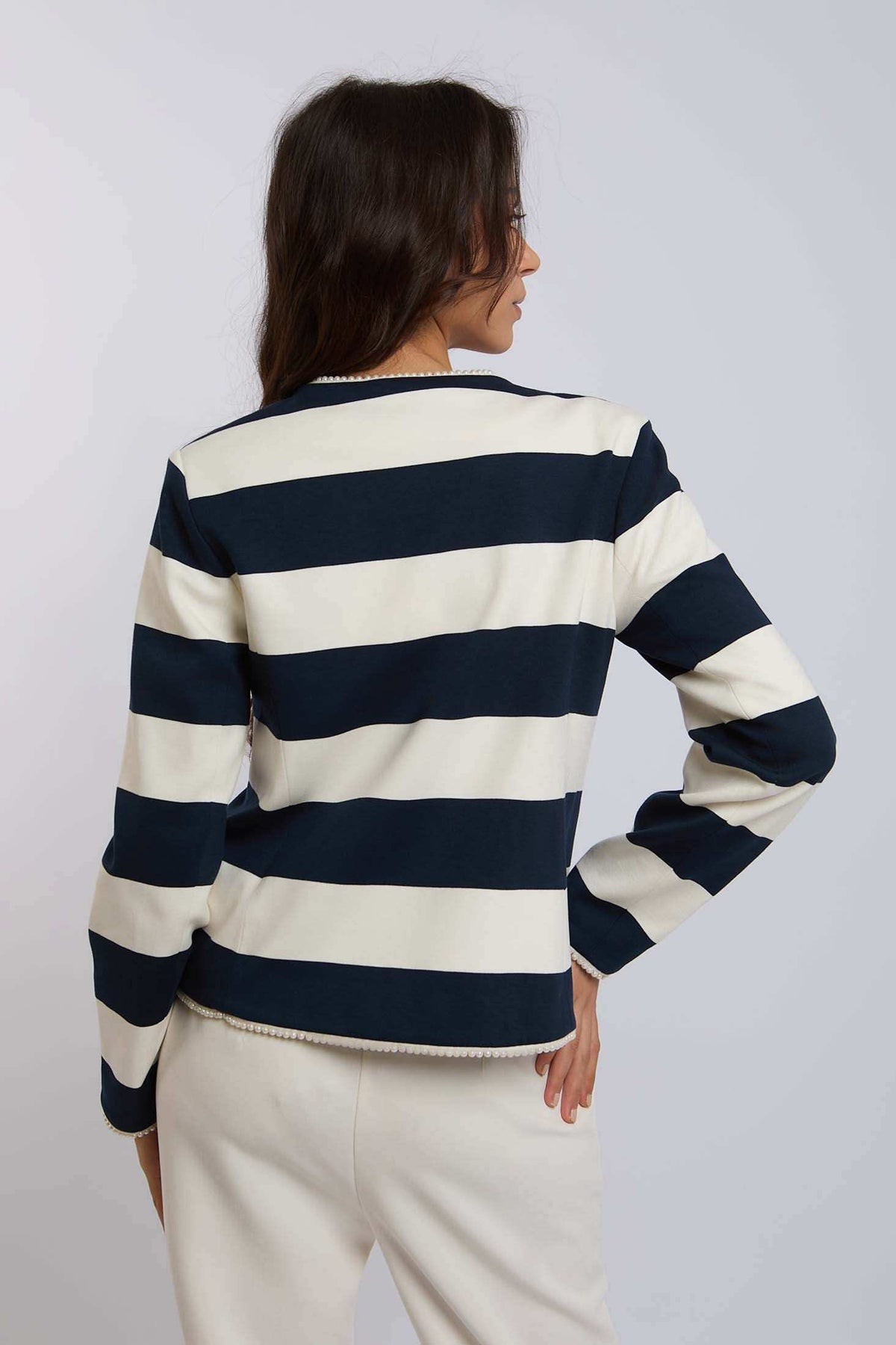 Woman wearing Dalydress navy and white striped long-sleeve top, back view