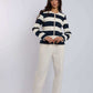Woman modeling Dalydress navy and white striped jacket with cream trousers, studio background