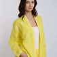 Woman wearing a yellow embroidered linen jacket and matching pants, casual outfit