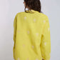 Woman wearing yellow embroidered long-sleeve shirt and matching pants, back view