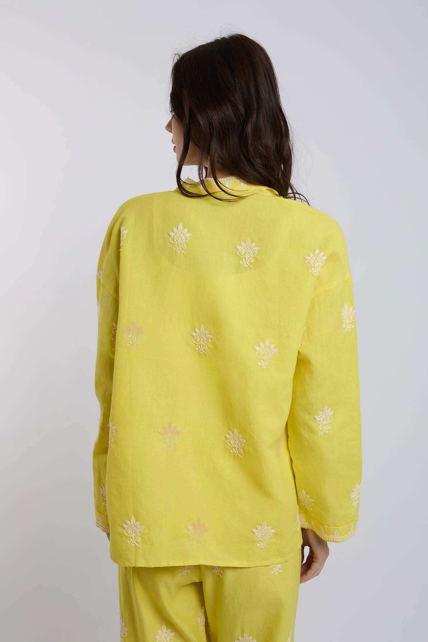 Woman wearing yellow embroidered long-sleeve shirt and matching pants, back view