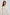 Woman wearing cream long sleeve dress with eyelet sleeves and gold chain detail