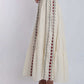 Woman wearing cream maxi skirt with red and black embroidered vertical patterns