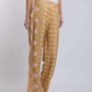 Woman wearing yellow patterned wide-leg pants and white sleeveless top