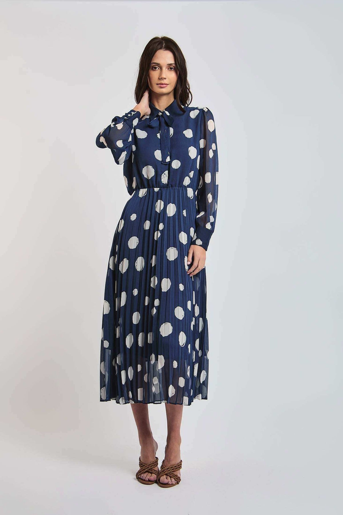 Woman wearing Dalydress blue polka dot pleated midi dress with long sleeves