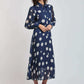 Woman wearing Dalydress navy blue polka dot midi dress with long sleeves and pleated skirt