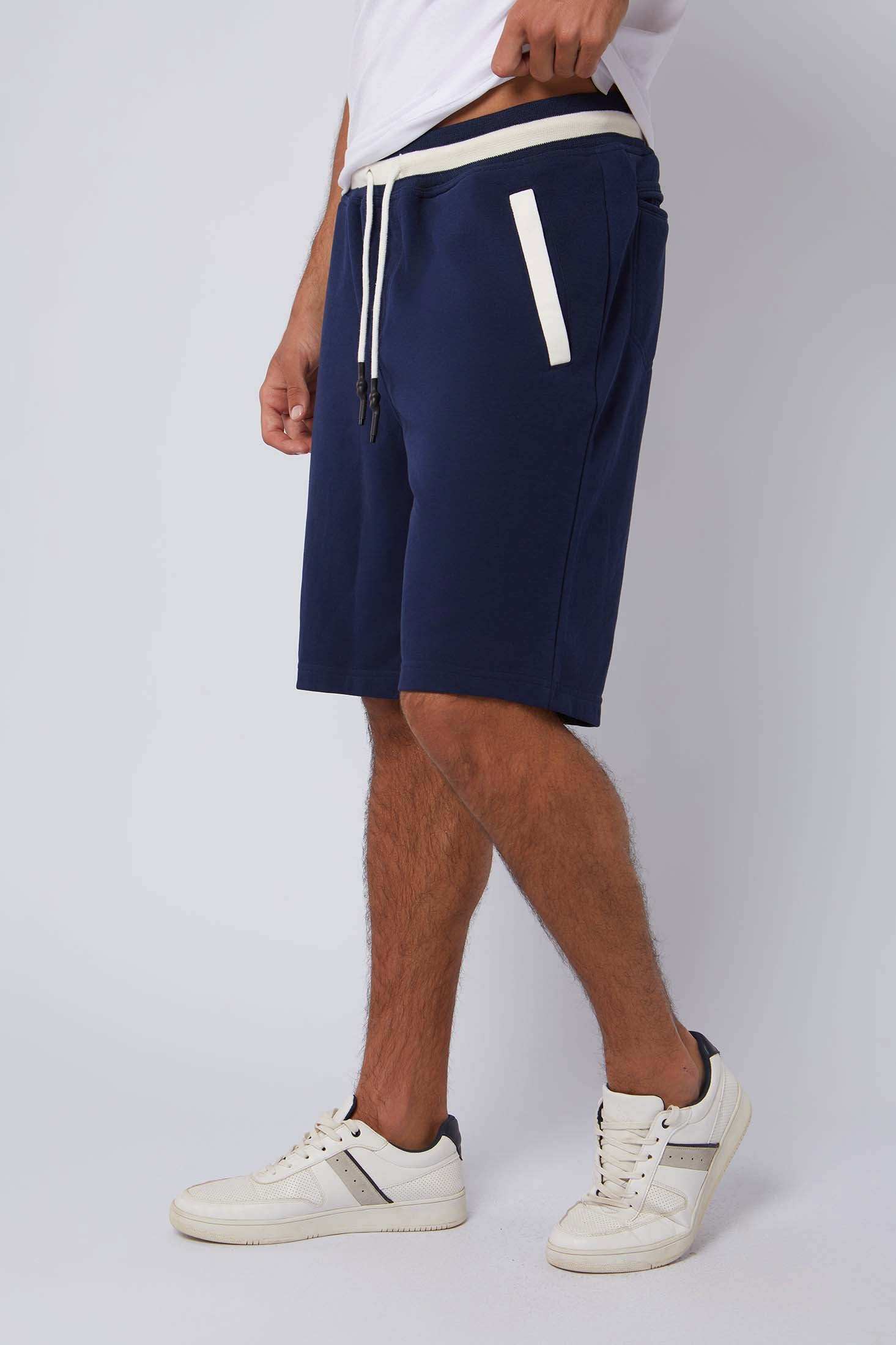 Dalydress men's navy blue shorts with white waistband and side pocket accents, styled with sneakers