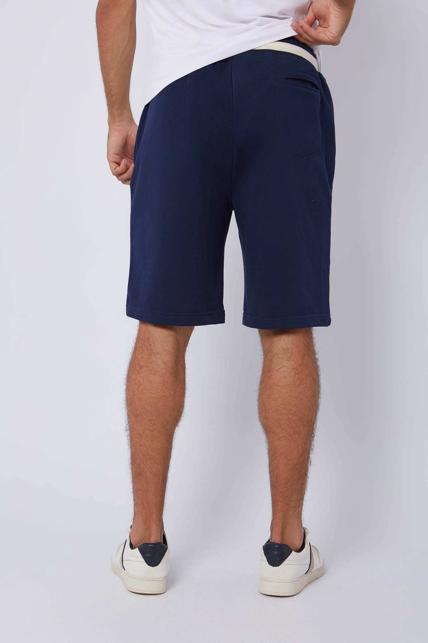 Dalydress men's navy blue casual shorts, back view, styled with white sneakers on model