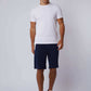 Dalydress men's casual white t-shirt and navy shorts outfit on model, studio background