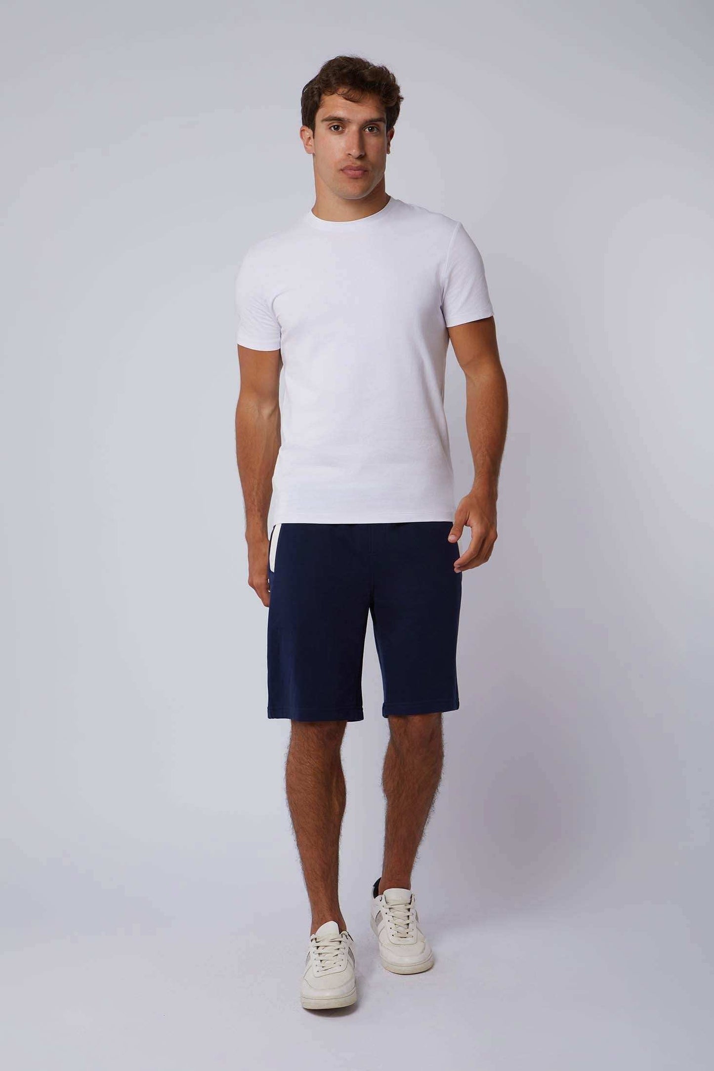 Dalydress men's casual white t-shirt and navy shorts outfit on model, studio background