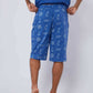 Man wearing blue Dalydress shorts with nautical anchor and wheel print, photographed from behind