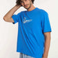 Dalydress men's casual look, blue surfboard tee and checkered shorts, studio background