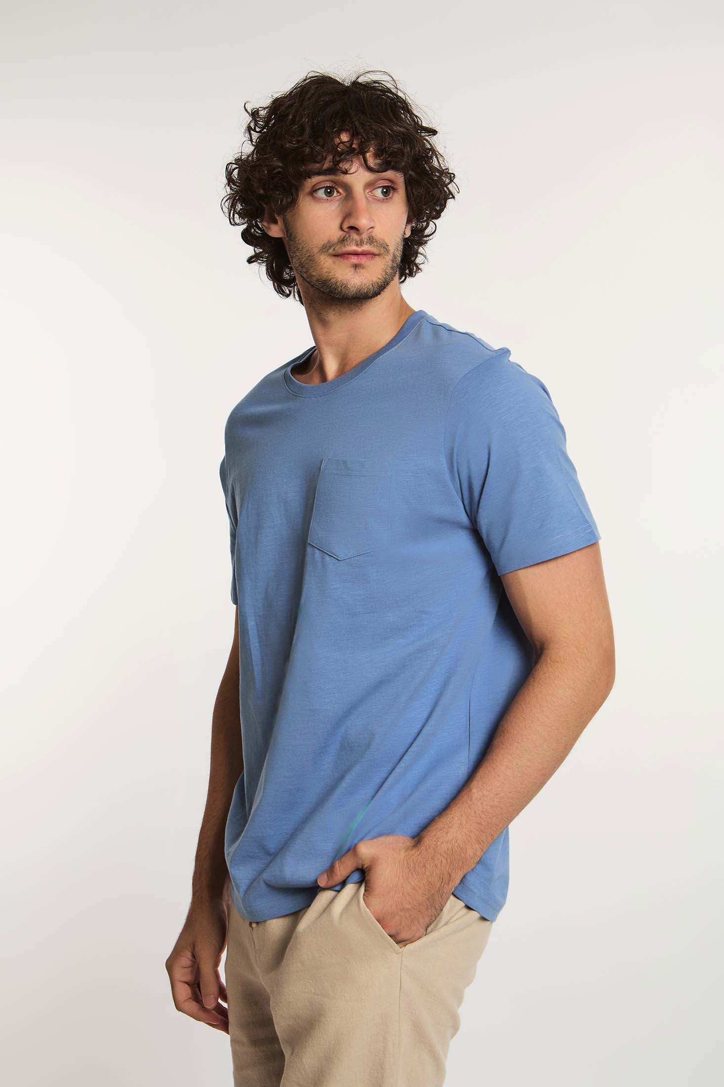Dalydress men's casual blue t-shirt with chest pocket and beige pants, studio background
