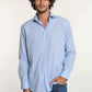 Man wearing light blue Dalydress men's shirt and blue jeans against white background