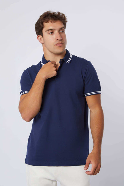 Man wearing Dalydress navy blue polo shirt with white trim, casual men's fashion.