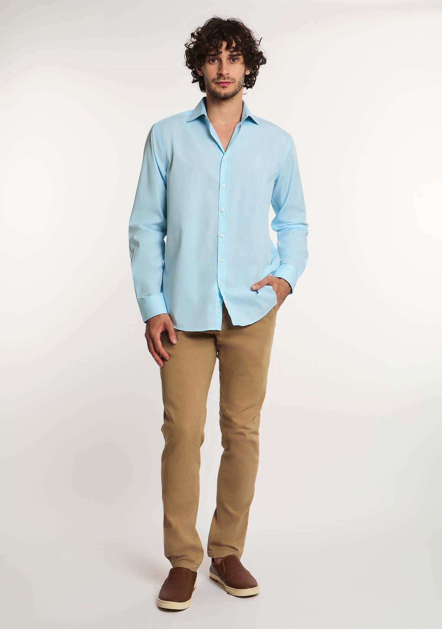 Man in light blue button-down shirt, beige pants, and brown shoes from Dalydress menswear collection