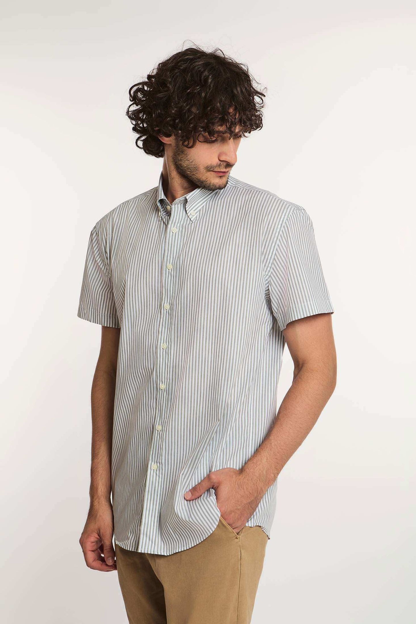 Man wearing Dalydress short-sleeve striped button-up shirt and beige pants, front view