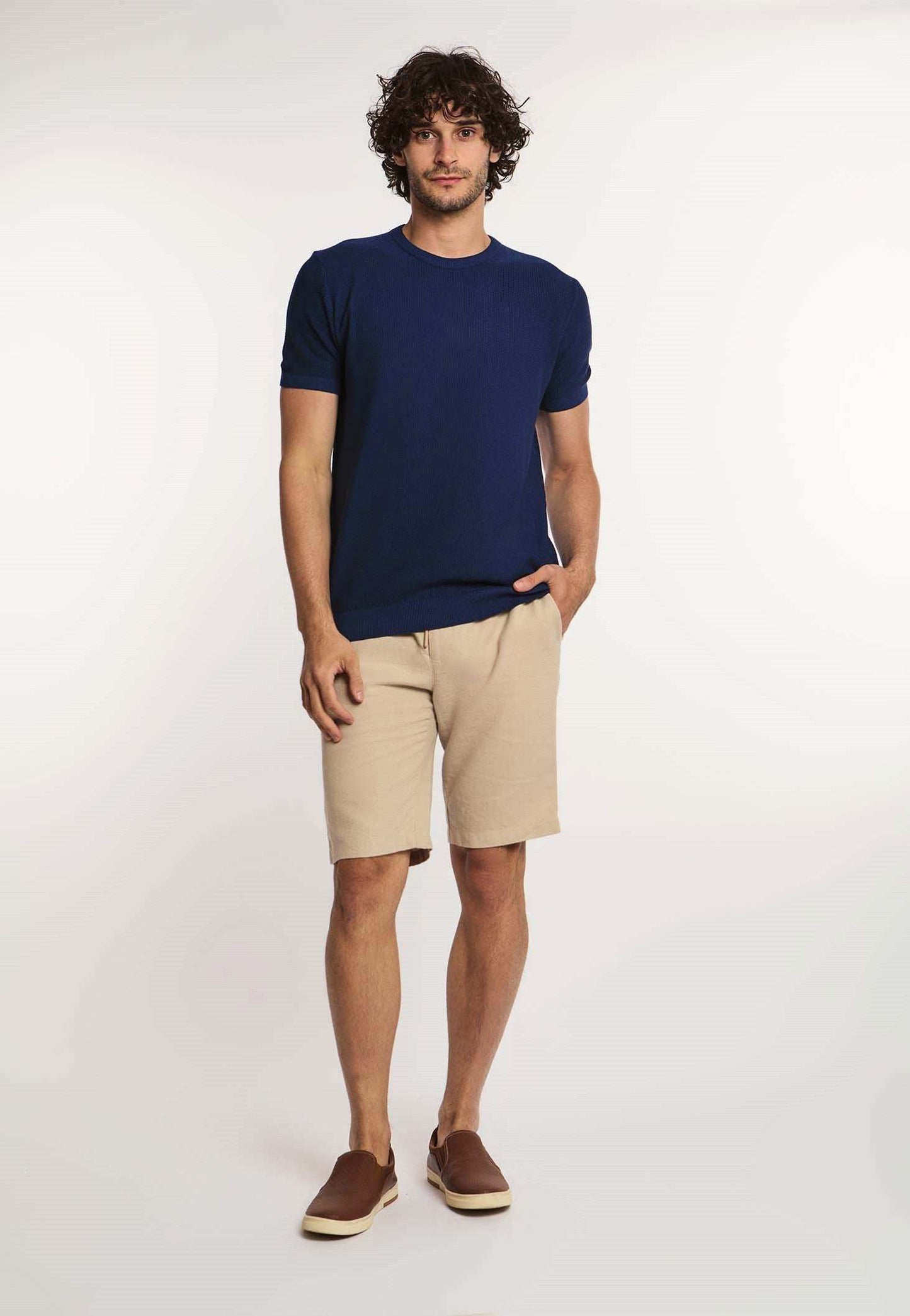 Dalydress men's casual look with navy t-shirt, beige shorts, and brown slip-on shoes