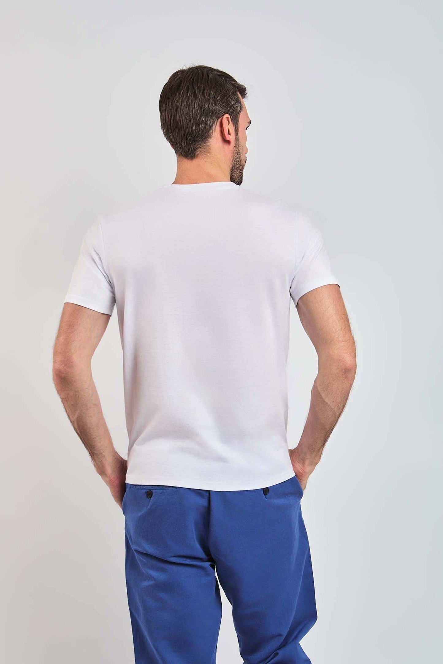 Dalydress men's casual white t-shirt and blue pants, back view, studio setting