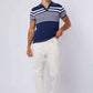Man wearing Dalydress blue striped polo shirt and white pants, casual men's fashion