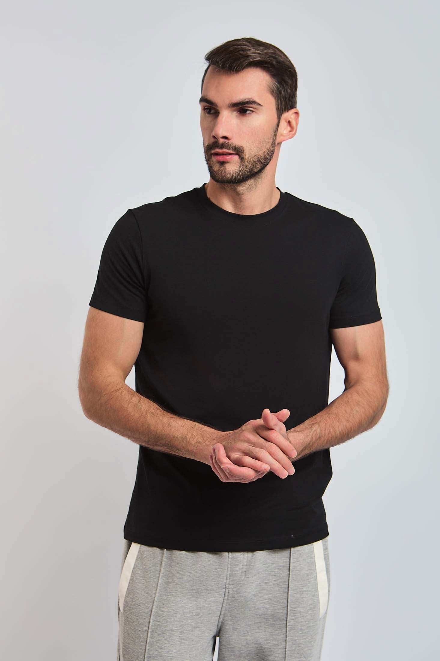 Man wearing Dalydress black t-shirt and grey joggers, casual menswear fashion
