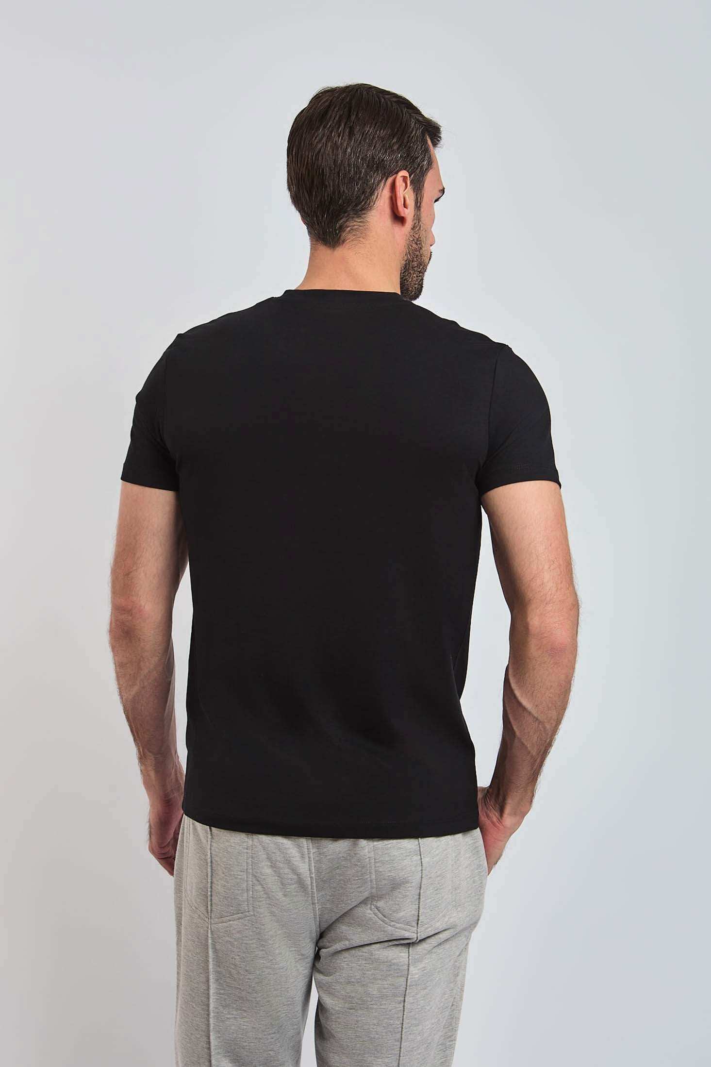 Dalydress men's black short sleeve t-shirt, back view, paired with light grey pants