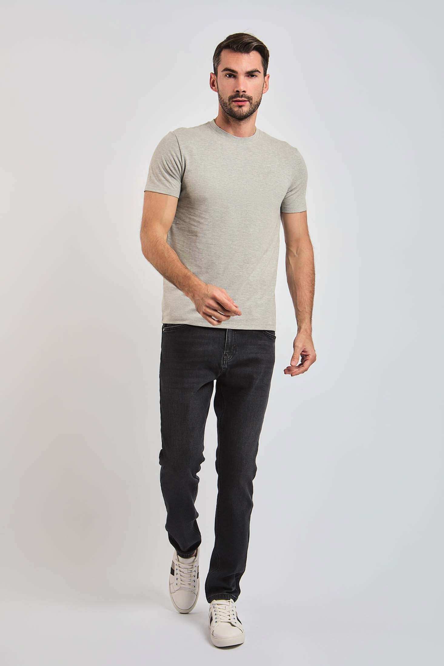 Dalydress men's fashion model in light grey t-shirt, dark jeans, and white sneakers