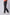 Dalydress men's black jeans styled with white sneakers and a coral shirt, side view