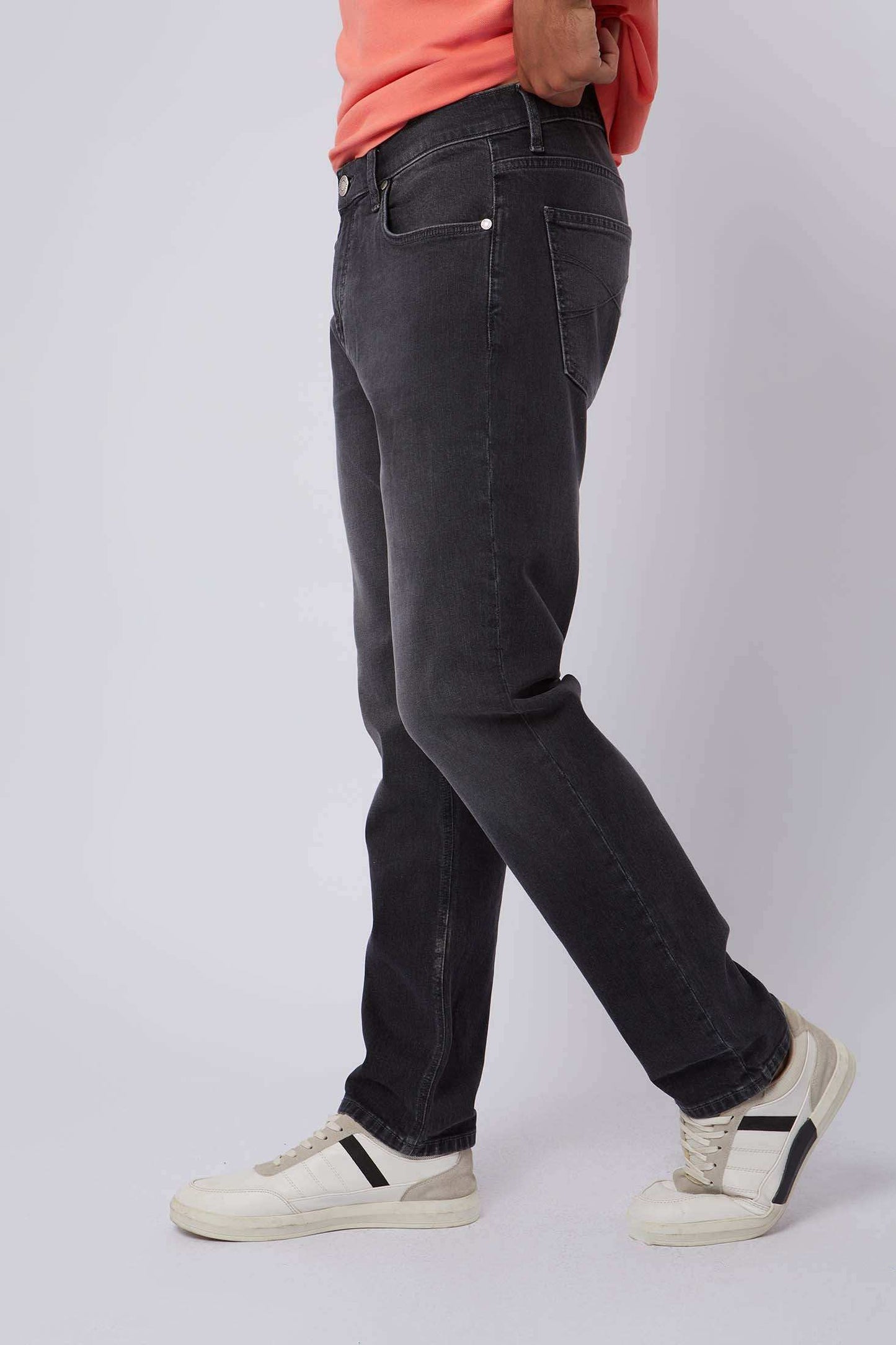 Dalydress men's black jeans styled with white sneakers and a coral shirt, side view