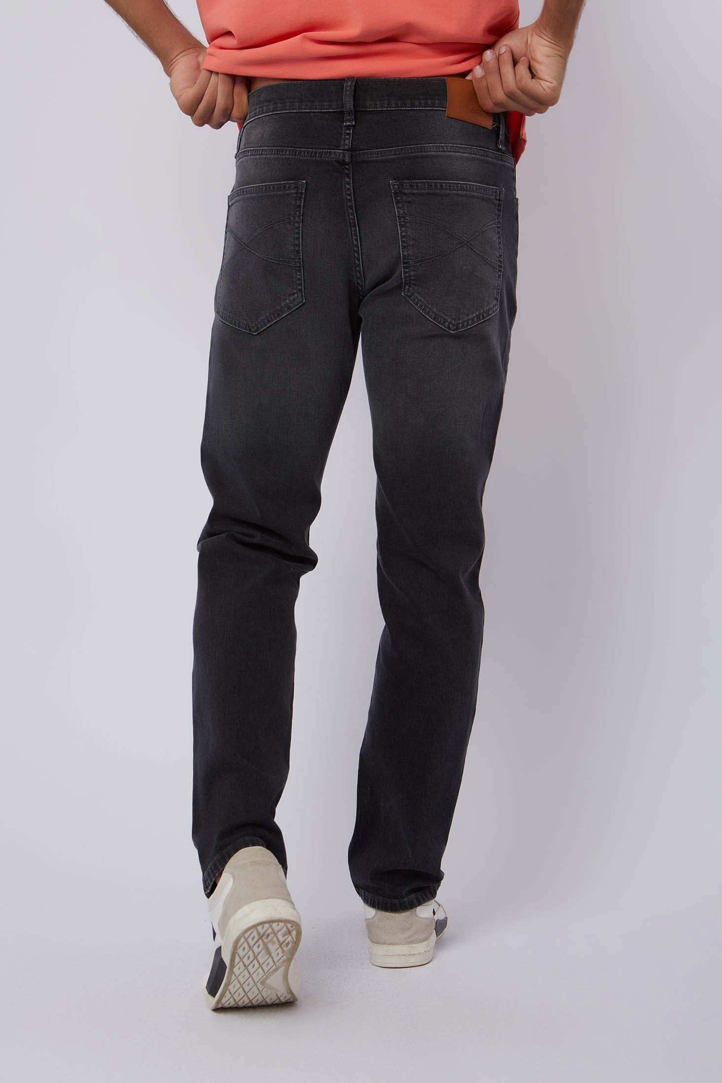 Dalydress men's black denim jeans back view with casual orange shirt and white sneakers