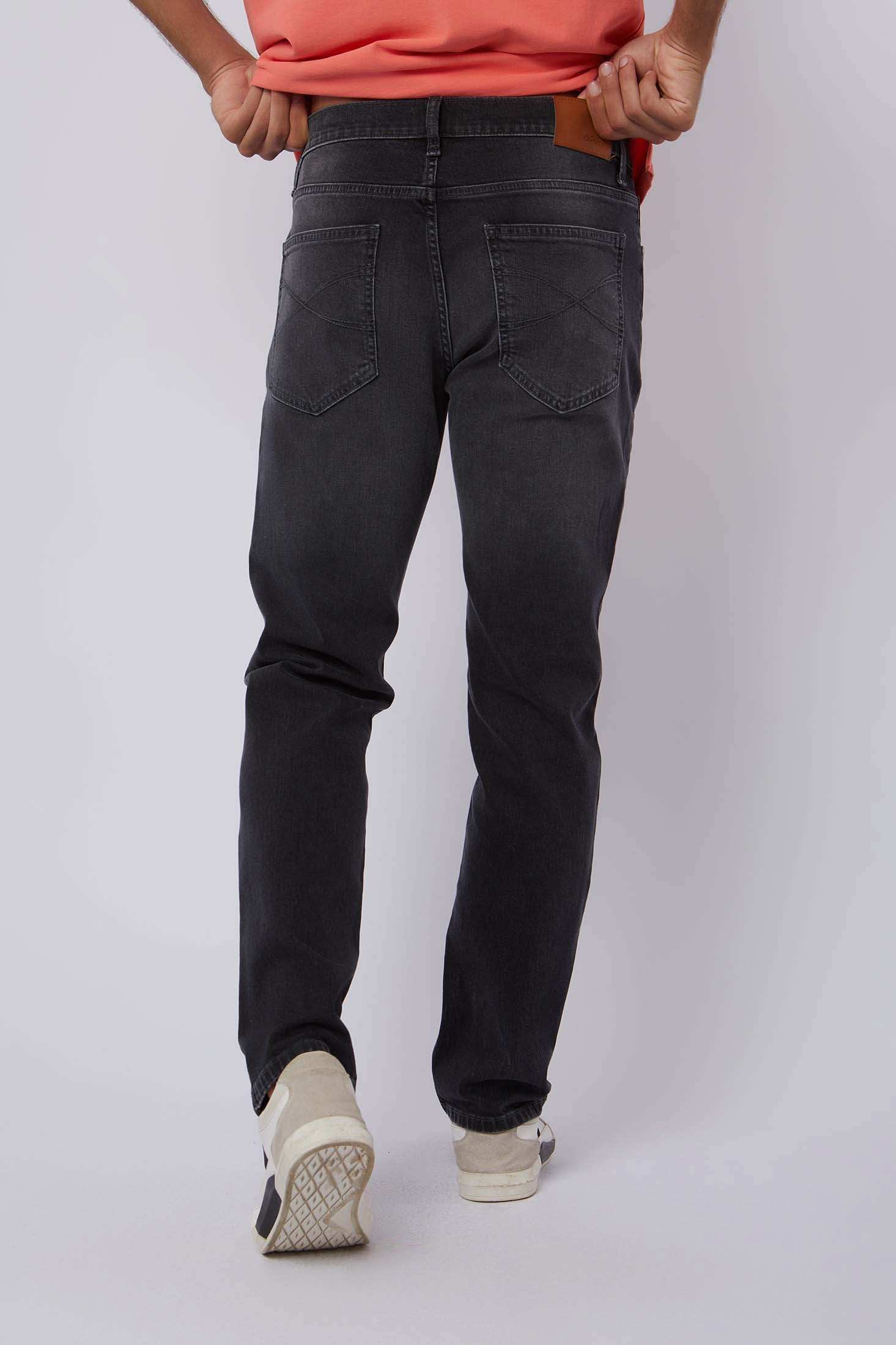 Dalydress men's black denim jeans back view with casual orange shirt and white sneakers