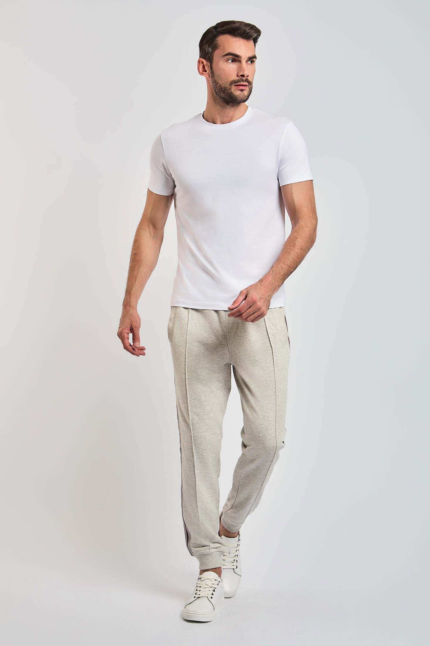 Dalydress men's casual wear, model in white t-shirt, beige pants, white sneakers