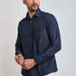 Man wearing a long sleeve dark denim shirt with chest pockets and white pants