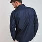 Man wearing long sleeve dark denim shirt and white pants, back view, casual style
