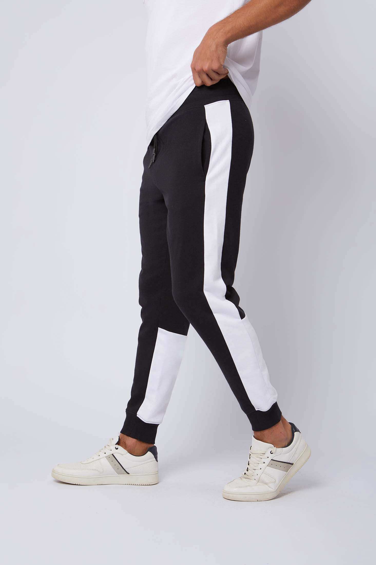 Men’s black jogger pants with white side stripes, casual athletic wear, white sneakers