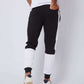 Man wearing black and white colorblock joggers and white sneakers, rear view