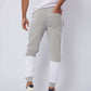 Back view of man wearing grey and white jogger pants and white sneakers