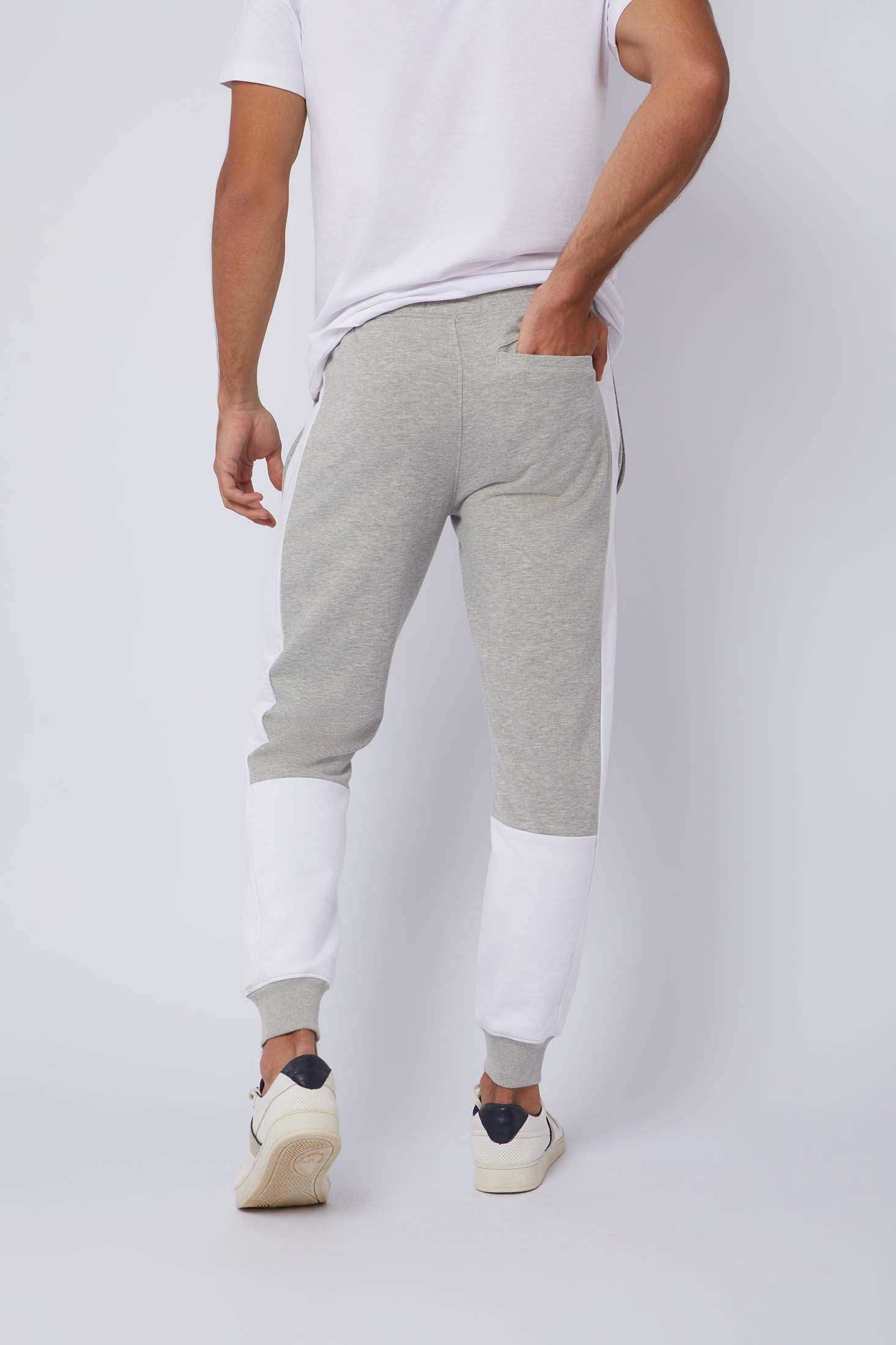 Back view of man wearing grey and white jogger pants and white sneakers