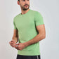 Man wearing light green short sleeve crew neck t-shirt and black pants