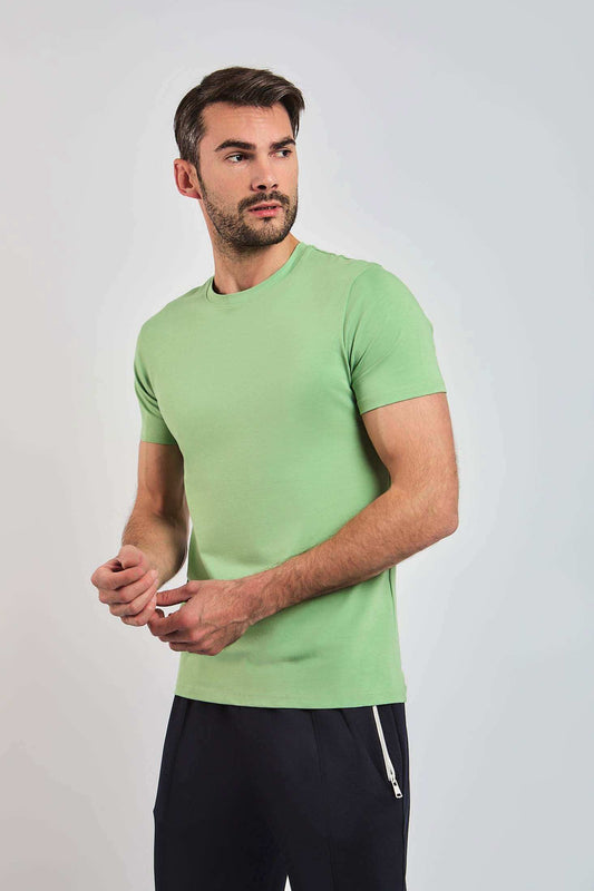 Man wearing light green short sleeve crew neck t-shirt and black pants