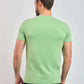 Man wearing light green short sleeve t-shirt, viewed from the back, on plain background