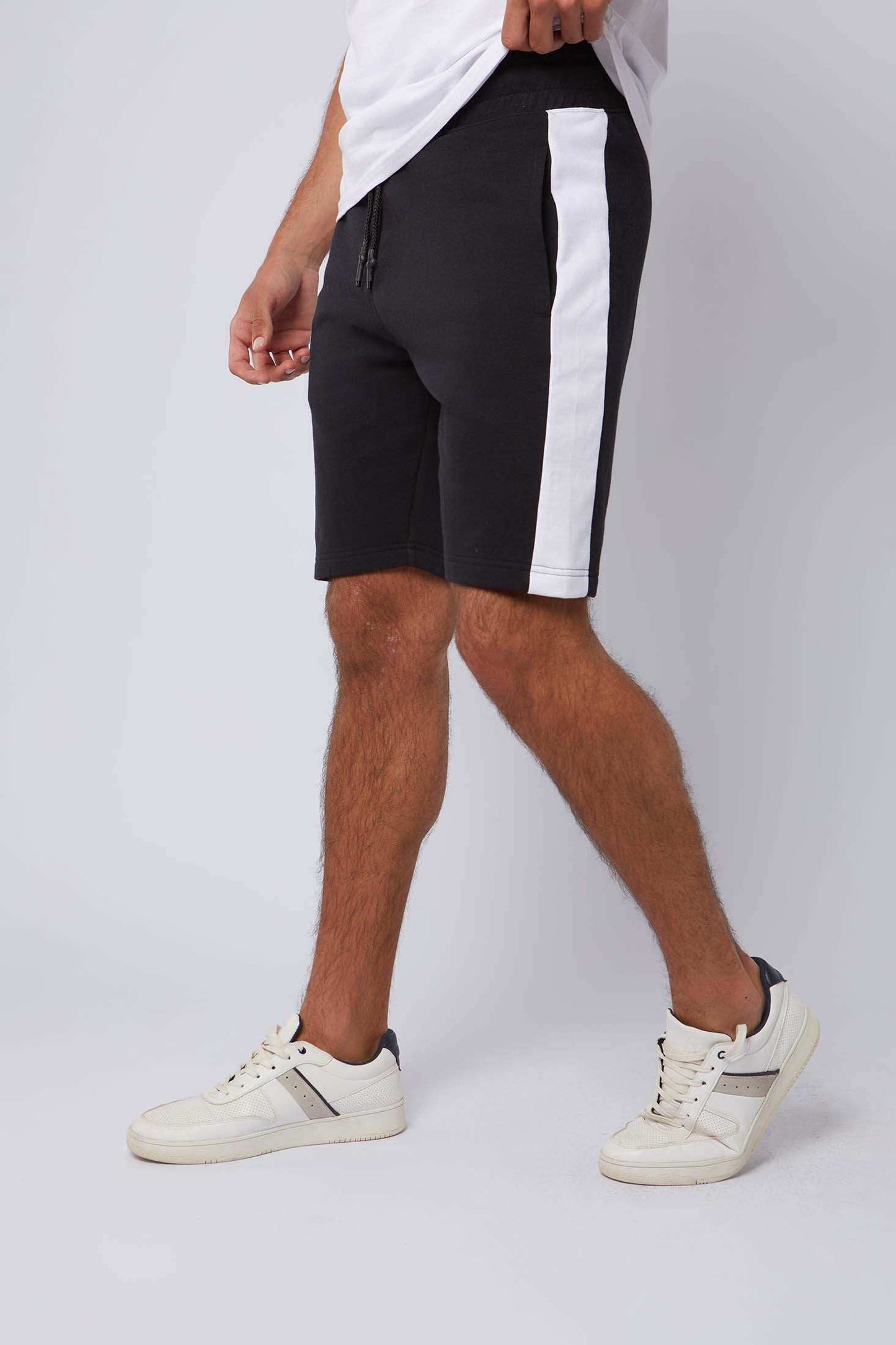 Men's black shorts with white side stripe, casual wear, styled with white sneakers